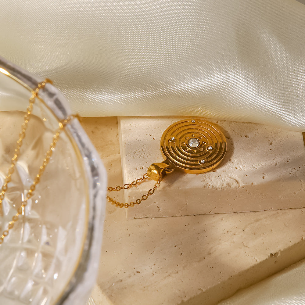 Alžběta – Zlatý náhrdelník s malými symbolickými přívěsky.